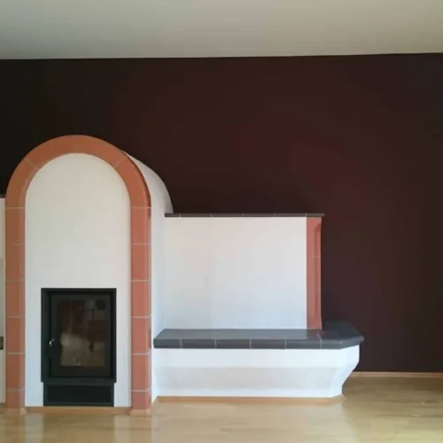 Matte Akzentwand in einem tiefen Braunton, gestaltet mit ökologischer Kreidefarbe hinter einem modern eingefassten Kamin.