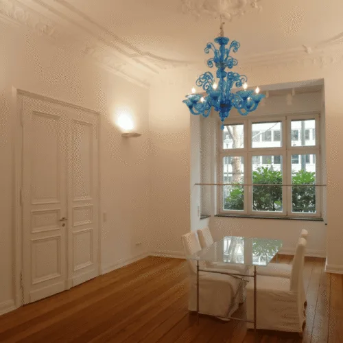 Hell renovierter Altbauraum mit frisch weiß lackierten Flügeltüren und aufwendigen Stuckverzierungen an der Decke.