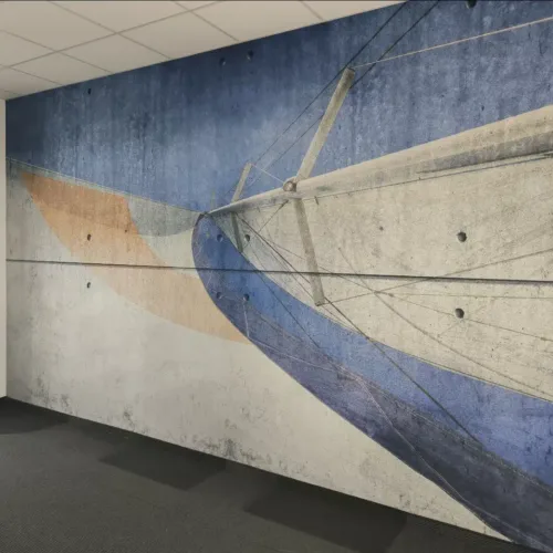 Großflächige Fototapete mit abstraktem Segelschiff-Motiv auf einer Wand in Betonoptik in einem modernen Büroraum.
