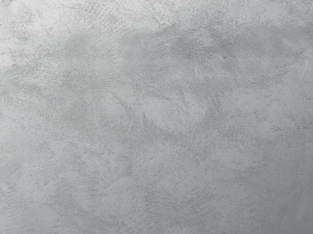 Täuschend echte Betonoptik-Wandgestaltung in einem modernen Wohnzimmer mit puristischer Einrichtung