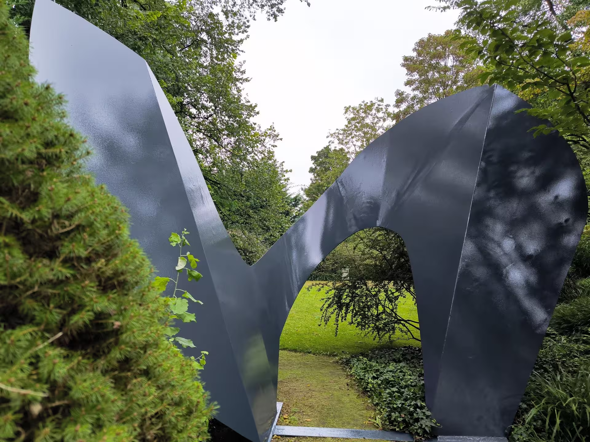 Großes, speziallackiertes Metallkunstwerk (Stahlskulptur) als Tordurchgang in einem Garten in Monheim, fachgerecht lackiert von Ihrem Maler für Düsseldorf und Monheim